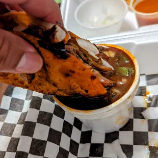 a hand dipping a tortilla