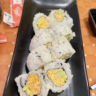 four pieces of sushi on a black plate