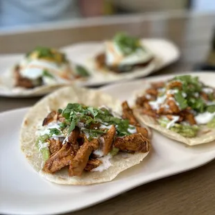 three tacos on a white plate