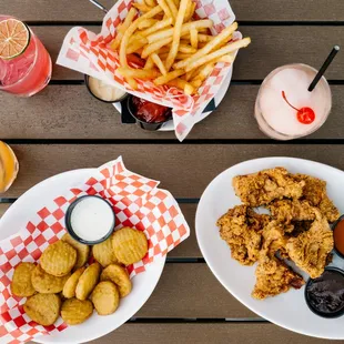 two plates of fried chicken and fries