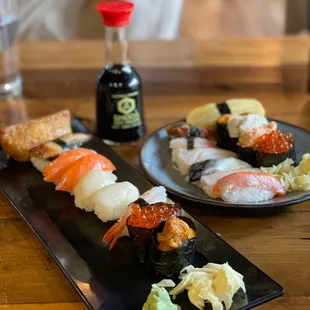 two plates of sushi and a bottle of sake