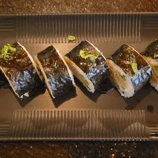 a plate of sushi with a variety of toppings