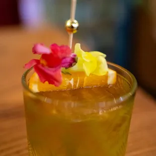 a shot of a drink with a flower garnish