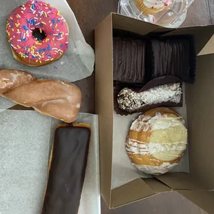 Donuts, cheese Danish, vanilla cupcake and a cannoli with pistachios.