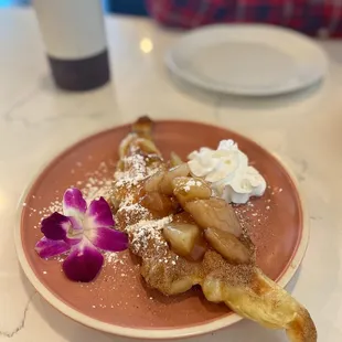 a plate of french fries with whipped cream and a flower