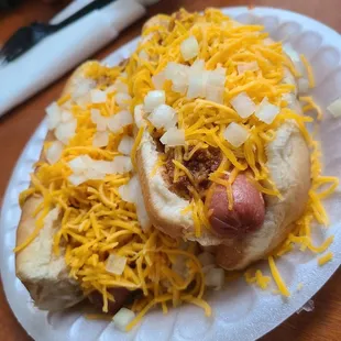 two hot dogs covered in cheese