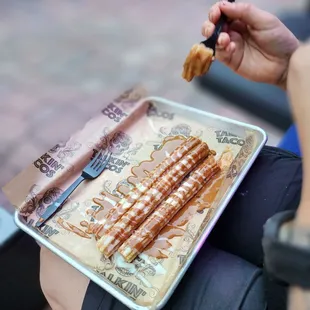  a person holding a tray of food