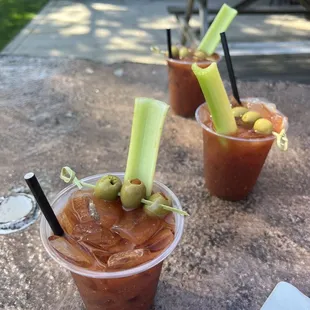 two bloody drinks with olives and celery