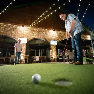 Tall Tales has an outdoor patio with a putting green, umbrellas, more large-screen TVs.