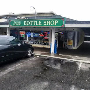 a car parked in front of a bottle shop