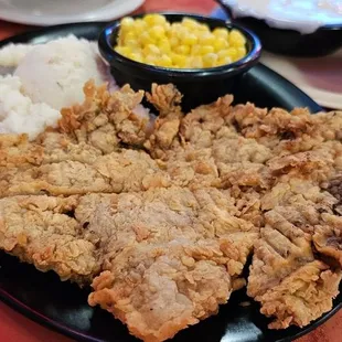 a plate of fried chicken, rice, and corn