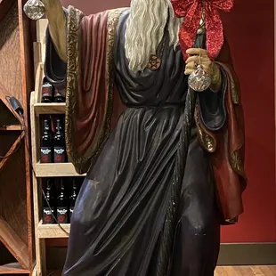 a statue of a wizard holding a wine glass