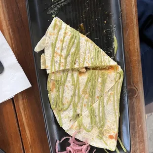 Quesadilla with chicken and topped with avocado sauce.
