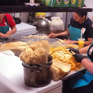 These ladies are like a well-oiled machine, churning out tamales at incredible speed!