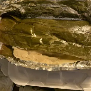 Chicken tamales w/ salsa verde in banana leaves