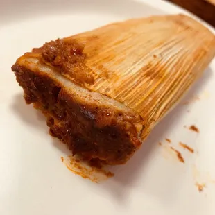 A very moist and tender pork with red sauce tamale.