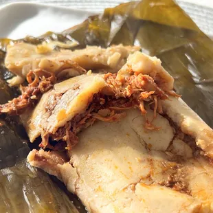 Chicken Rojo Tamales wrapped in banana leaf