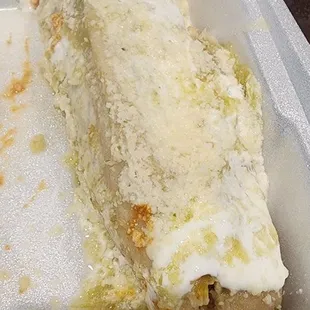 a close up of a burrito in a styrofoam container