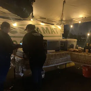 two people standing under a tent