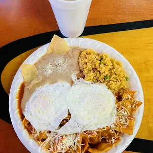 Red chilaquiles eggs over medium and a champurrado