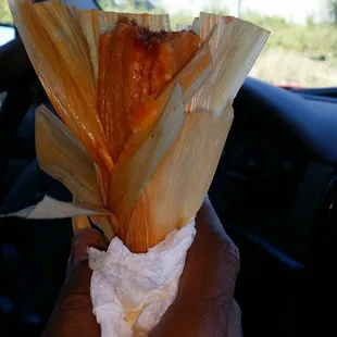 a person holding a tamales