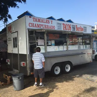 a man standing in front of a taco truck
