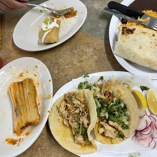 a plate of chicken tacos, tortillas, and a tortilla