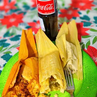 a plate of tamales and a coke