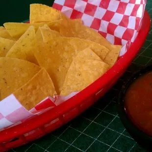 a basket of tortillas and a bowl of salsa