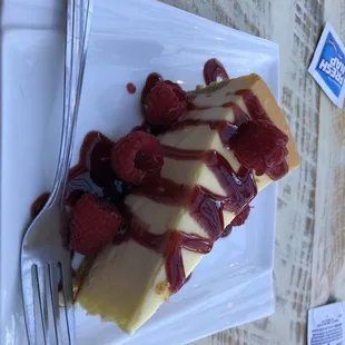 a slice of cheesecake with raspberries