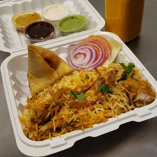 Chicken Biryani with Samosa (appetizer) and Mango Lassi (drink).
