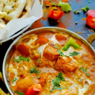 a bowl of curry and pita bread