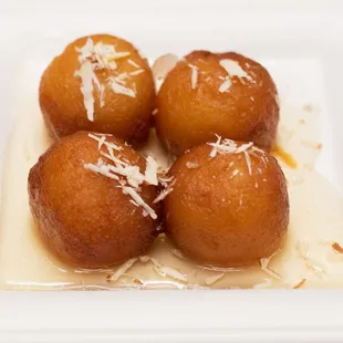 a white square plate with four donuts on it