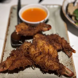 COCONUT PRAWNS Prawns coated with coconut flakes and served with mango &amp; chili sauce