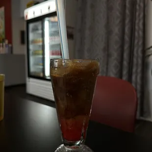 a cold beverage in a glass on a table