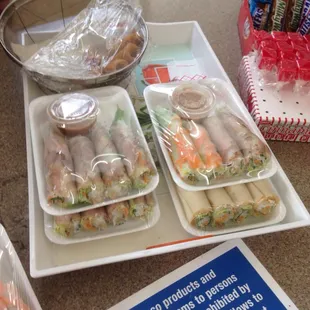 Salad and egg rolls for sale at front counter of gas station store