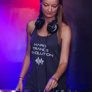 a female dj in a black tank top and headphones