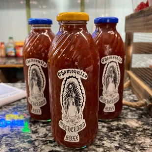 three bottles of sauce on a counter