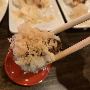 a close up of a plate of food with chopsticks