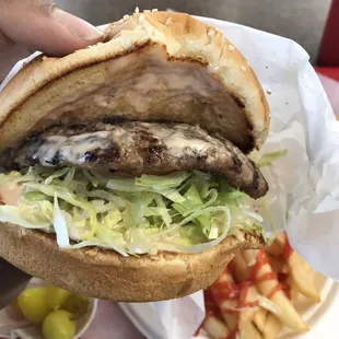 a hand holding a hamburger