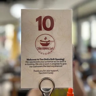 a table with a sign and a bottle of mustard