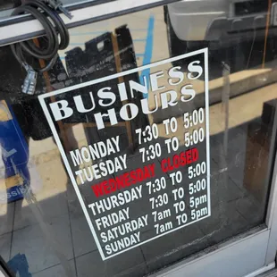 a business hours sign in a window
