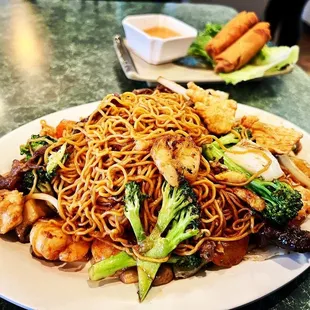 a plate of noodles with meat and vegetables