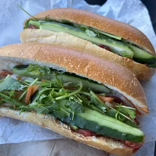 two sandwiches on a piece of wax paper