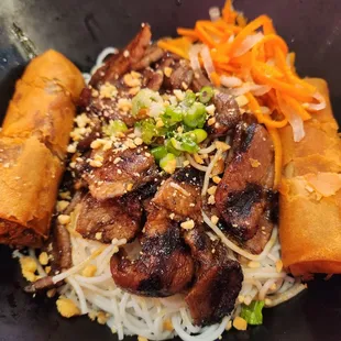 a bowl of noodles with meat and vegetables