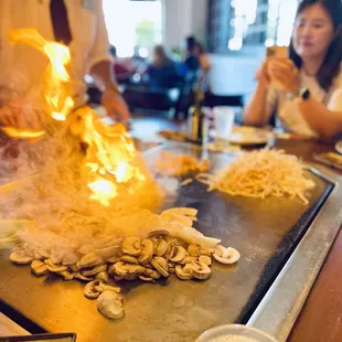 a woman cooking food on a grill