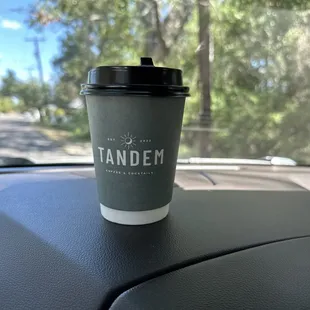 a coffee cup on the dashboard of a car