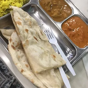 a tray of food with rice, curry, and naan bread