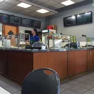 Counter with food on display, menu posted above.