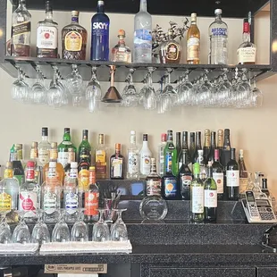 a shelf of liquor bottles and glasses